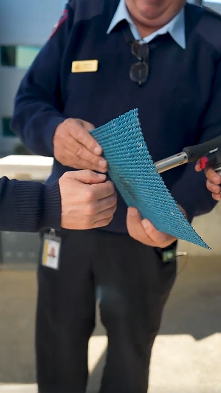 Firefighter in a navy uniform holding a sheet of blue coated INCA WFS net®