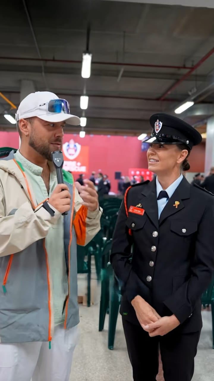 Presenter interviewing a firefighter in dress uniform at an event
