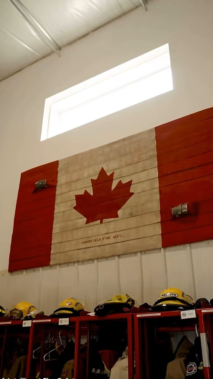 Canadian flag made of wood above firefighting gear in a fire station