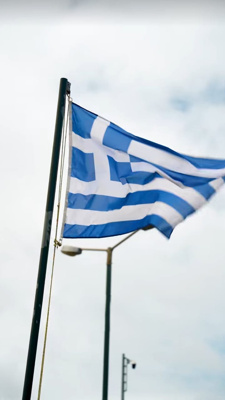 Greek flag flying against a cloudy sky