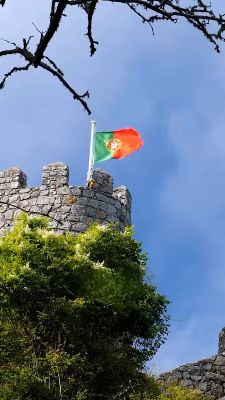 Portuguese flag flying above a castle wall