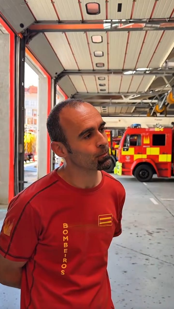 Spanish firefighter in a red Bomberos T-shirt at a fire station