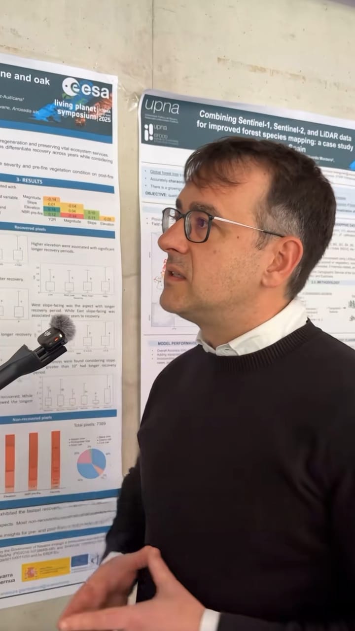 Researcher speaking in front of scientific posters