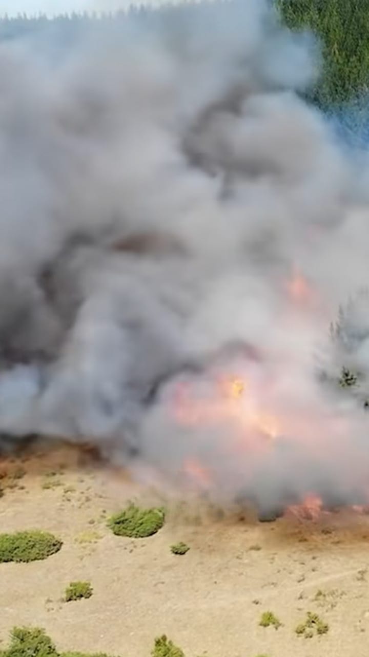 Smoke and flames rising from a fire in open countryside