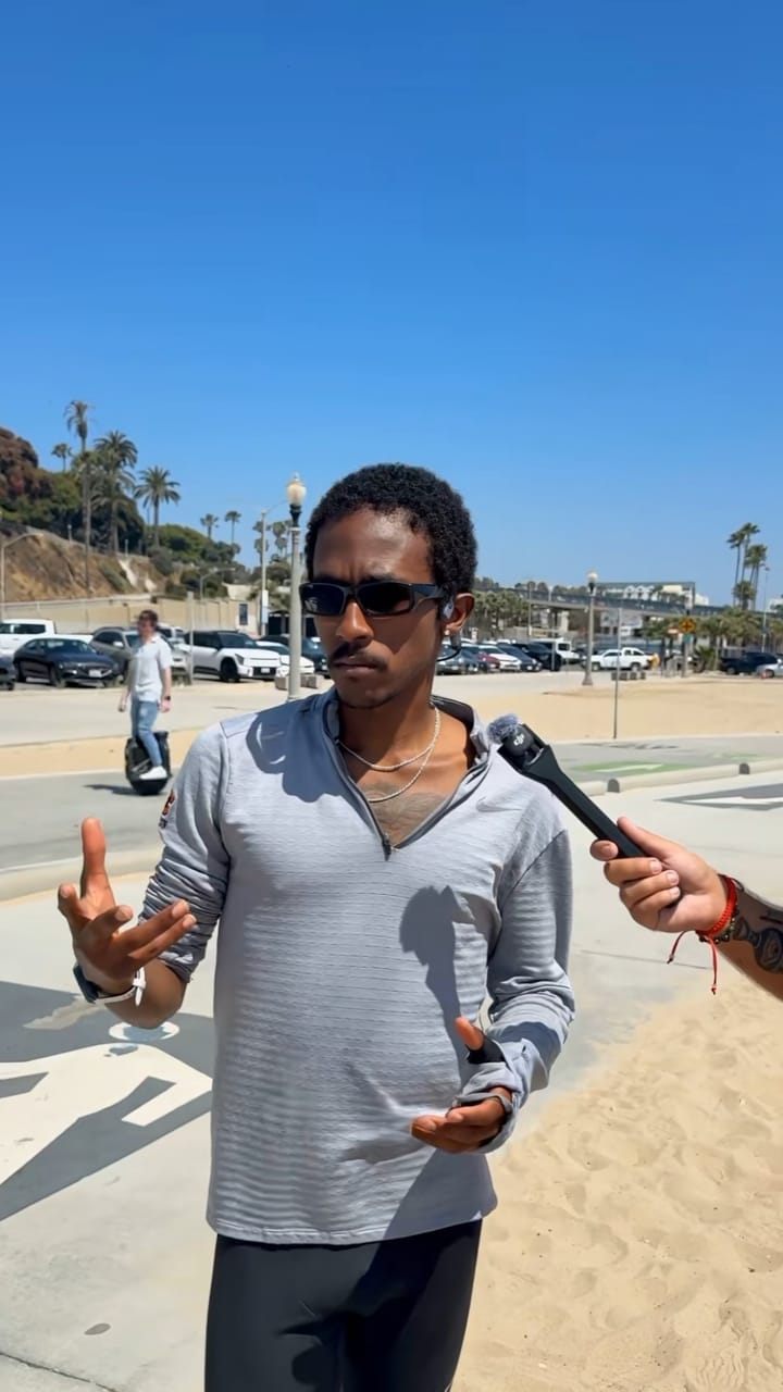 Man being interviewed on a beach promenade